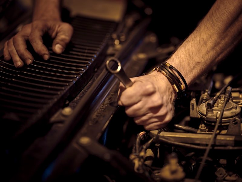 Hände mit Ringschlüssel am Motor