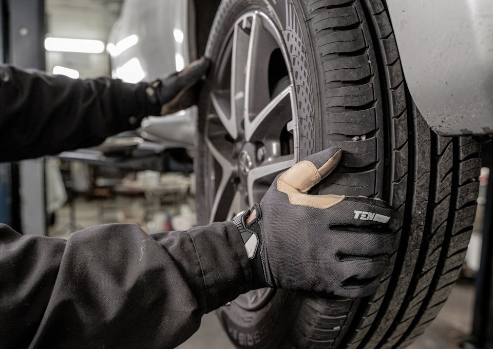 Hände in Arbeitshandschuhen setzen ein Rad an die Nabe